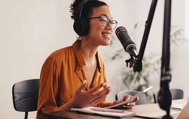 girl scout alum wearing headphones and talking into a microphone