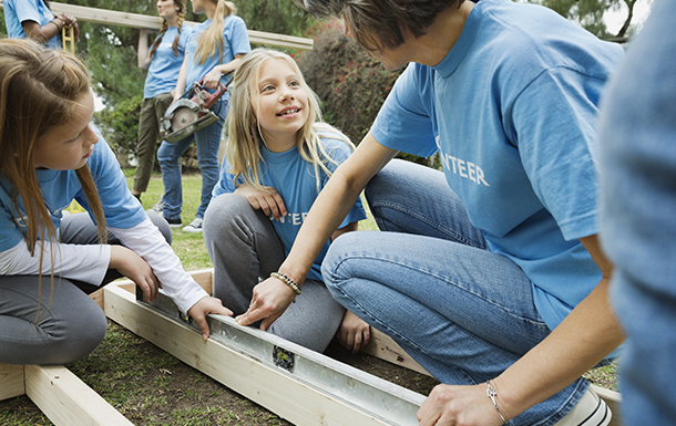 girl scouts working outside with a volunteer