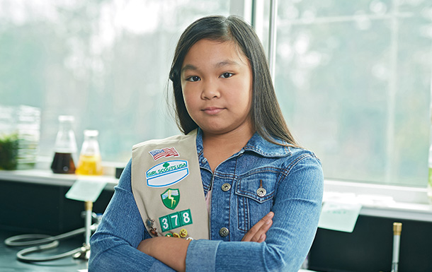 girl scout in a jean jacket with a sash