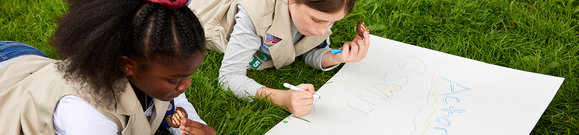  girl scouts creating a poster 