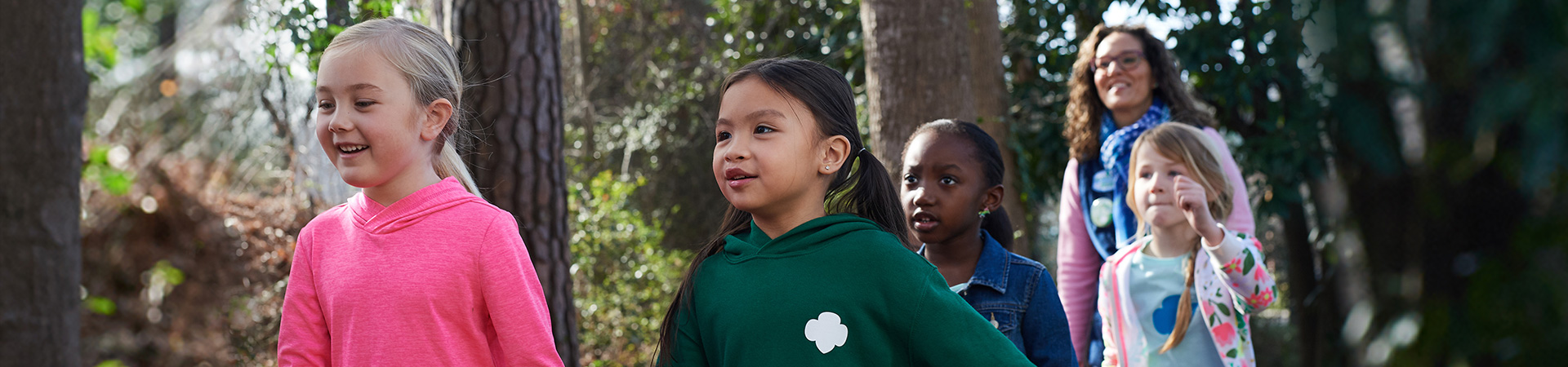  girl scouts outside hiking on a trail 