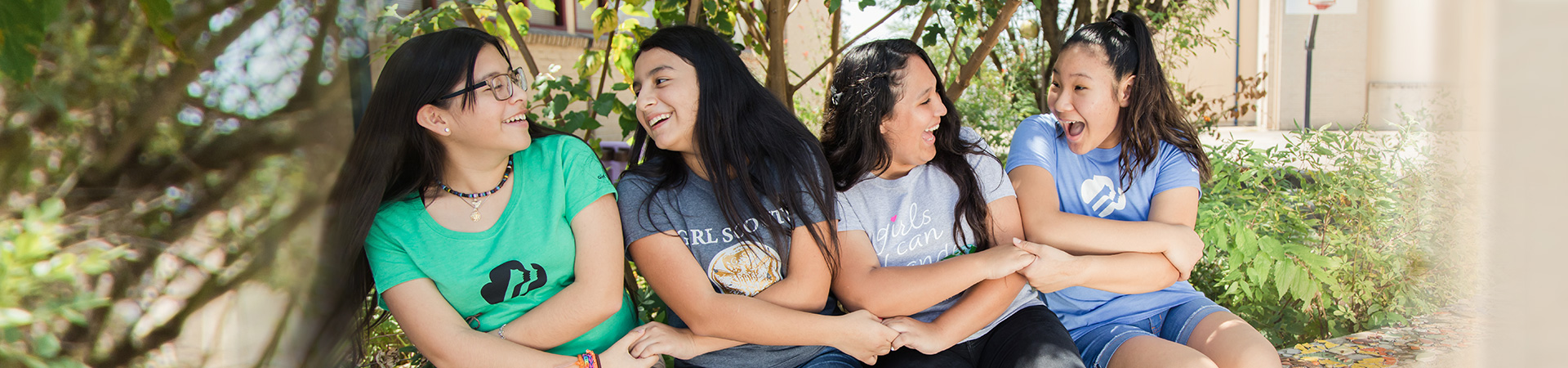  group of girl scouts sitting with arms crossed and hands linked 