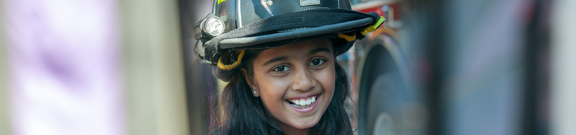  girl wearing a fire helmet 