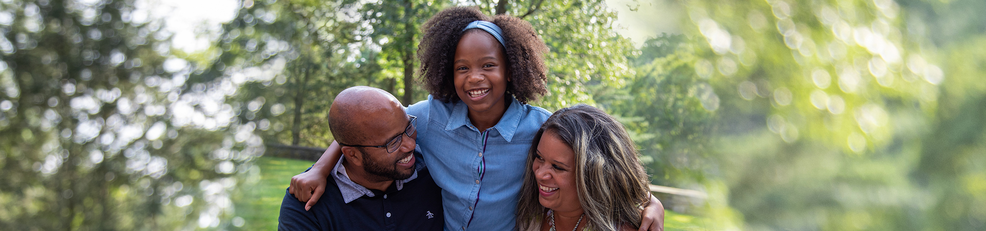  family with a girl around parents' shoulders 