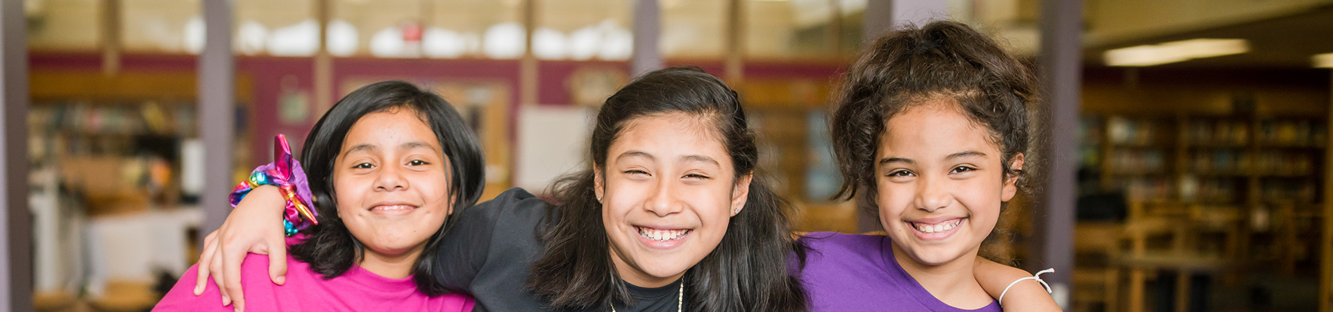  girl scouts with their arms wrapped around one another and smiling at the camera 