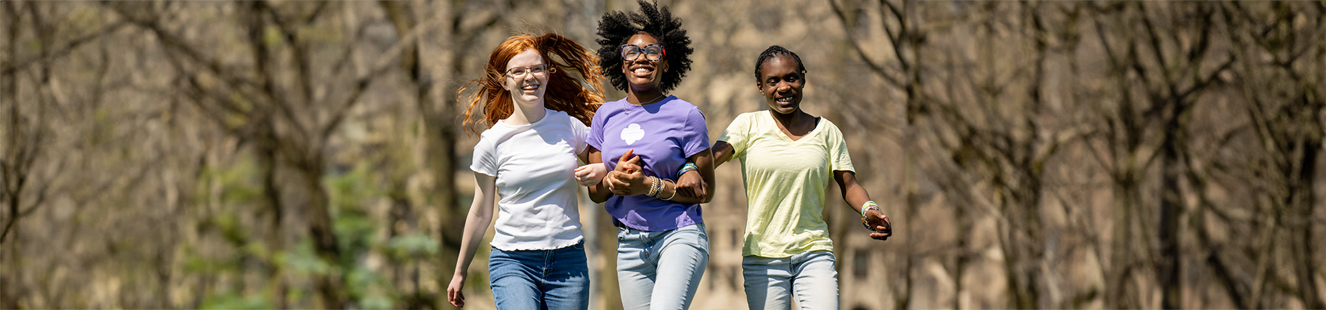  three high school girl scouts hugging and smiling at the camera 