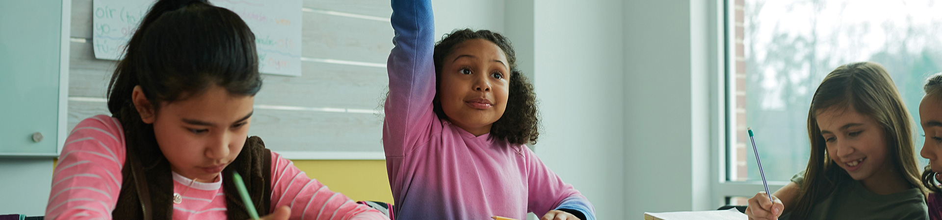  girl scout in classroom raising hand 